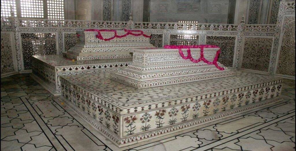 Intricate marble tombs of Mumtaz Mahal and Shah Jahan inside the Taj Mahal adorned with floral designs and carvings.